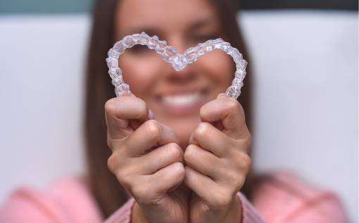 Woman with perfect smile after invisible invisalign aligners treatment